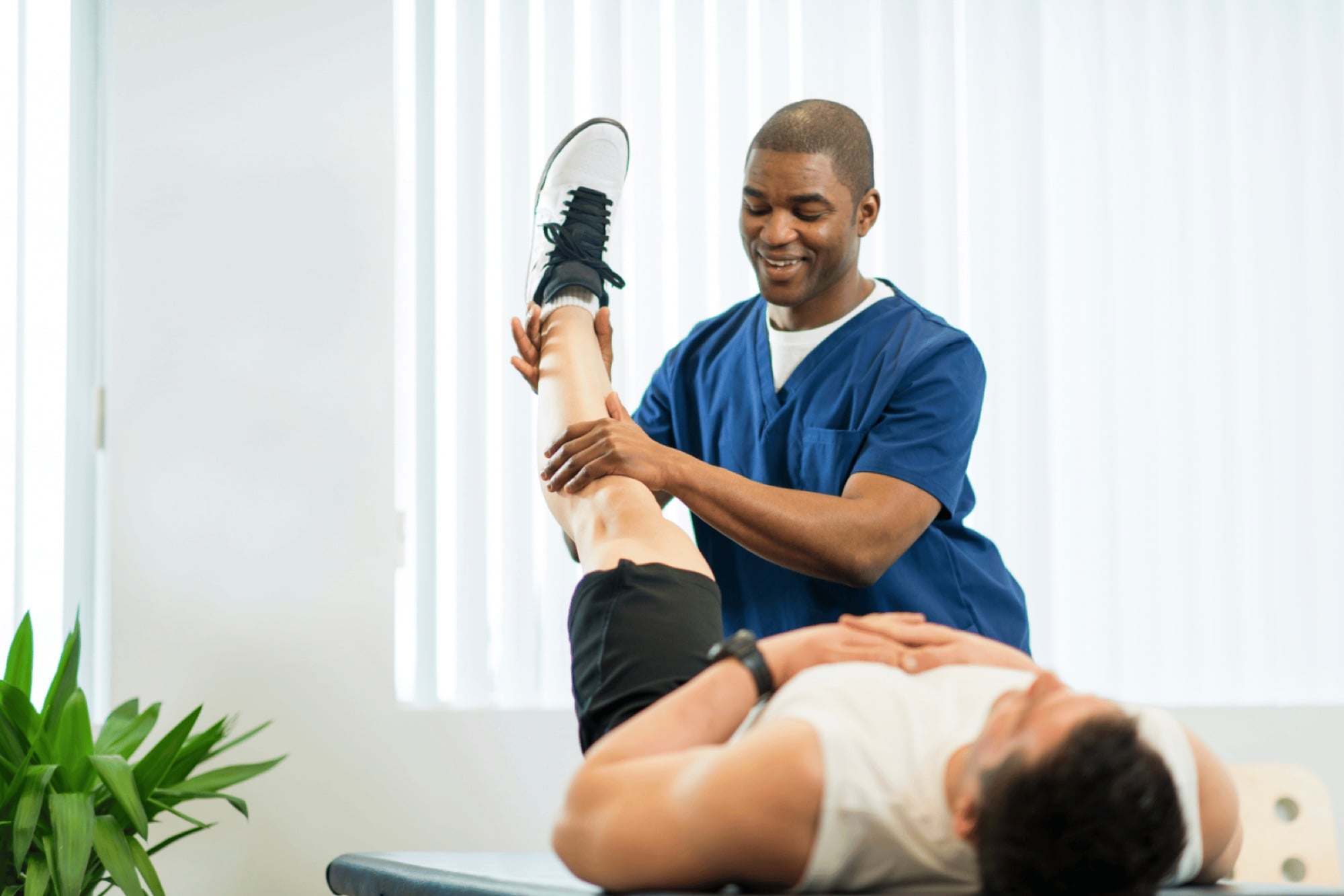 A physical therapist working with a patient in person